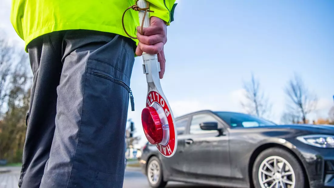 Ein Polizist ist bereit für eine Kontrolle. - Bild: Lino Mirgeler/dpa