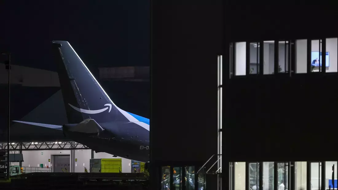 Ein Frachtflugzeug von Amazon steht neben einem Bürogebäude auf dem Flughafen Leipzig-Halle. - Bild: Jan Woitas/dpa