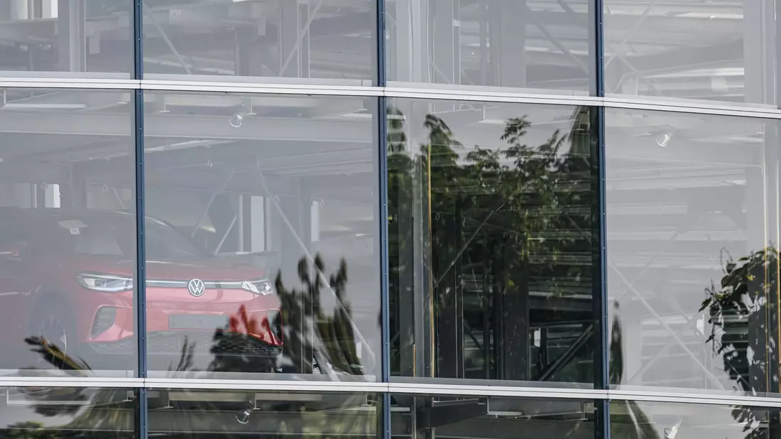 Ein Elektrofahrzeug ID.4 steht im Autoturm der Gläsernen VW-Manufaktur. Auch am Standort Dresden wird die Produktion vorübergehend gedrosselt. - Bild: Robert Michael/dpa/Symbolbild