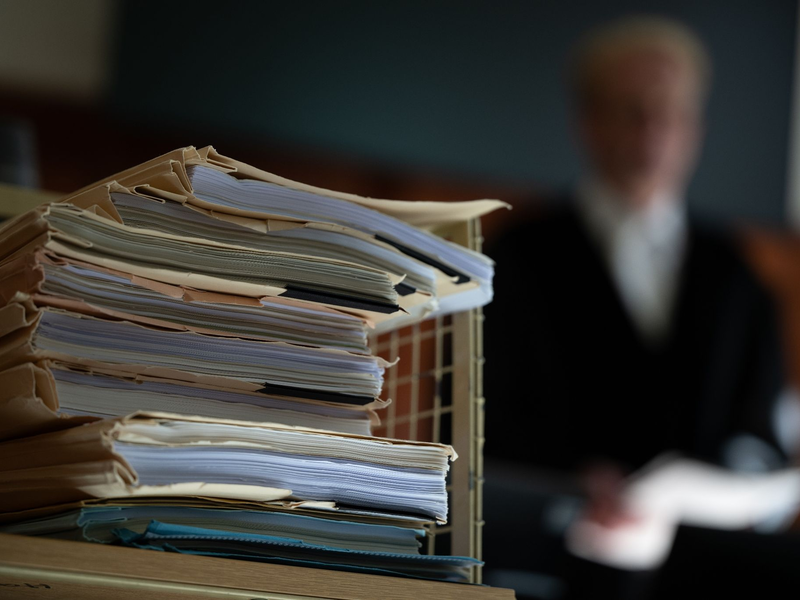 Prozessakten im Gerichtssaal. - Foto: Sebastian Christoph Gollnow/dpa