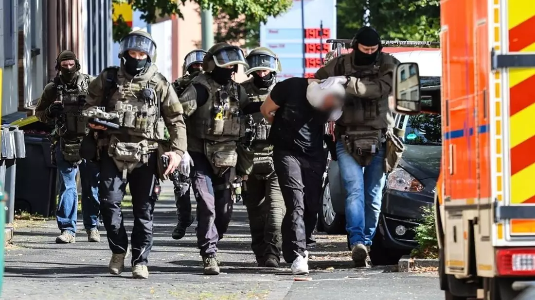 Spezialkräfte der Polizei führen den Verdächtigen ab. - Bild: Alex Talash/dpa