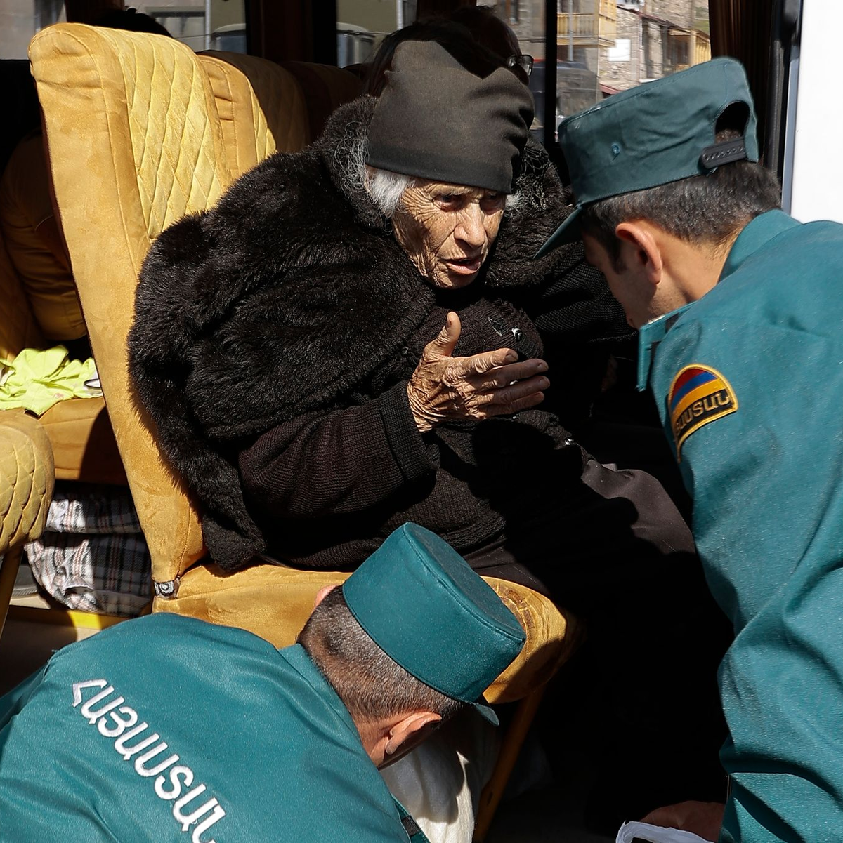 Mitarbeiter des armenischen Ministeriums für Notfallsituationen sprechen mit einer älteren armenischen Frau aus Berg-Karabach bei ihrer Ankunf in Goris. - Foto: Vasily Krestyaninov/AP/dpa