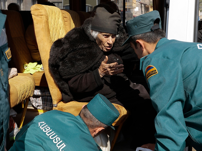 Mitarbeiter des armenischen Ministeriums für Notfallsituationen sprechen mit einer älteren armenischen Frau aus Berg-Karabach bei ihrer Ankunf in Goris. - Foto: Vasily Krestyaninov/AP/dpa