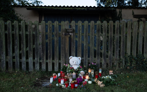 Menschen haben Kerzen, Blumen und ein Stofftier in Gedenken an die tote 14-Jährige vor einen Zaun gelegt. - Foto: Swen Pförtner/dpa