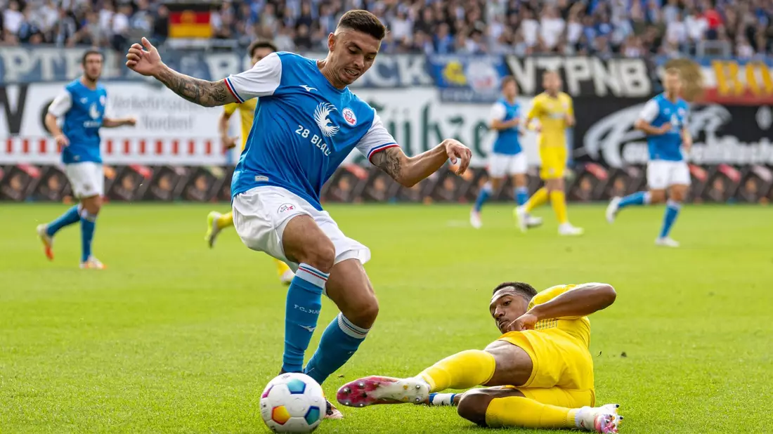 Die Rostocker um John-Patrick Strauß (l) setzten sich gegen Anton Donkor und Eintracht Braunschweig durch. - Bild: Marcus Völker/Fotostand/dpa