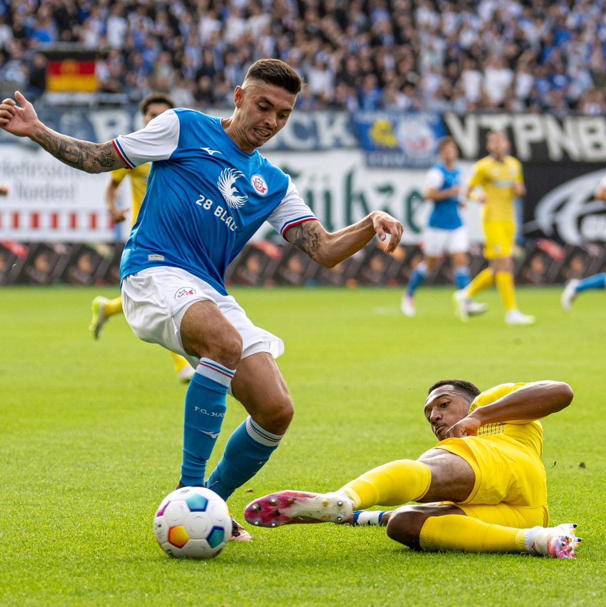 Die Rostocker um John-Patrick Strauß (l) setzten sich gegen Anton Donkor und Eintracht Braunschweig durch. - Foto: Marcus Völker/Fotostand/dpa