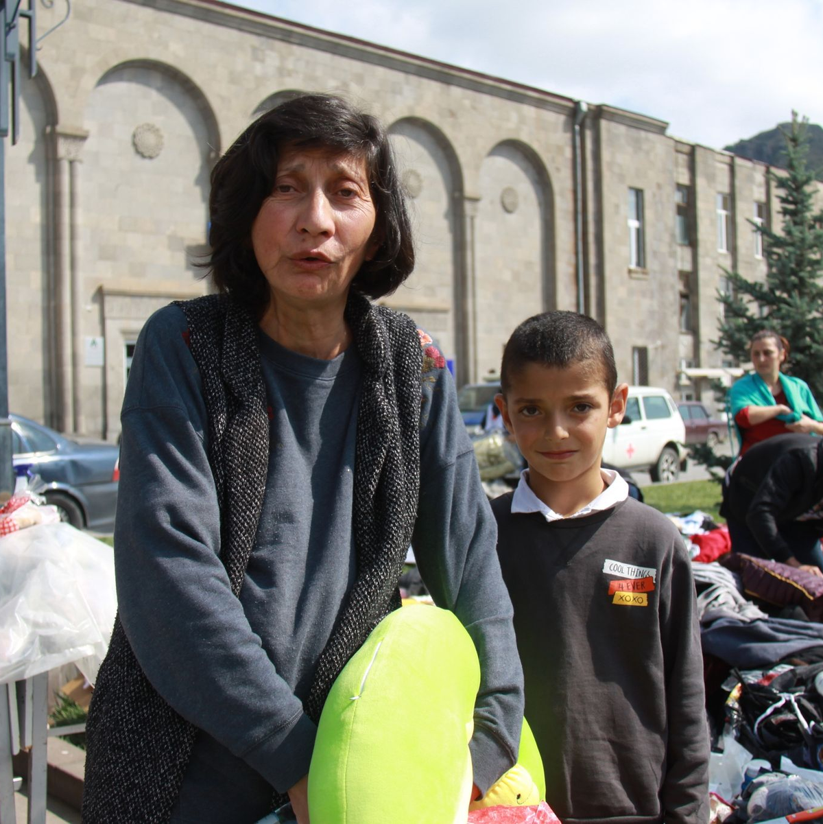 Margarita (l) und ihr Enkel Tigran sammeln nach der überstürzten Flucht aus Berg-Karabach Kleider. - Foto: André Ballin/dpa