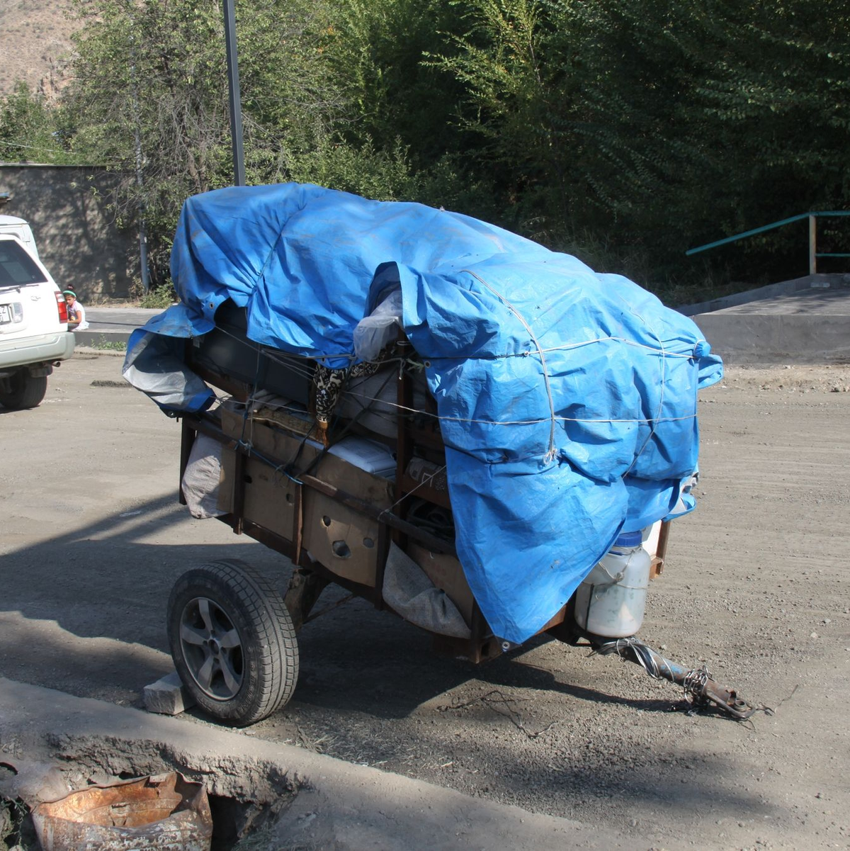 Schnell gepackt: Ein Anhänger mit Sachen von Flüchtlingen steht abgestellt am Straßenrand. - Foto: André Ballin/dpa
