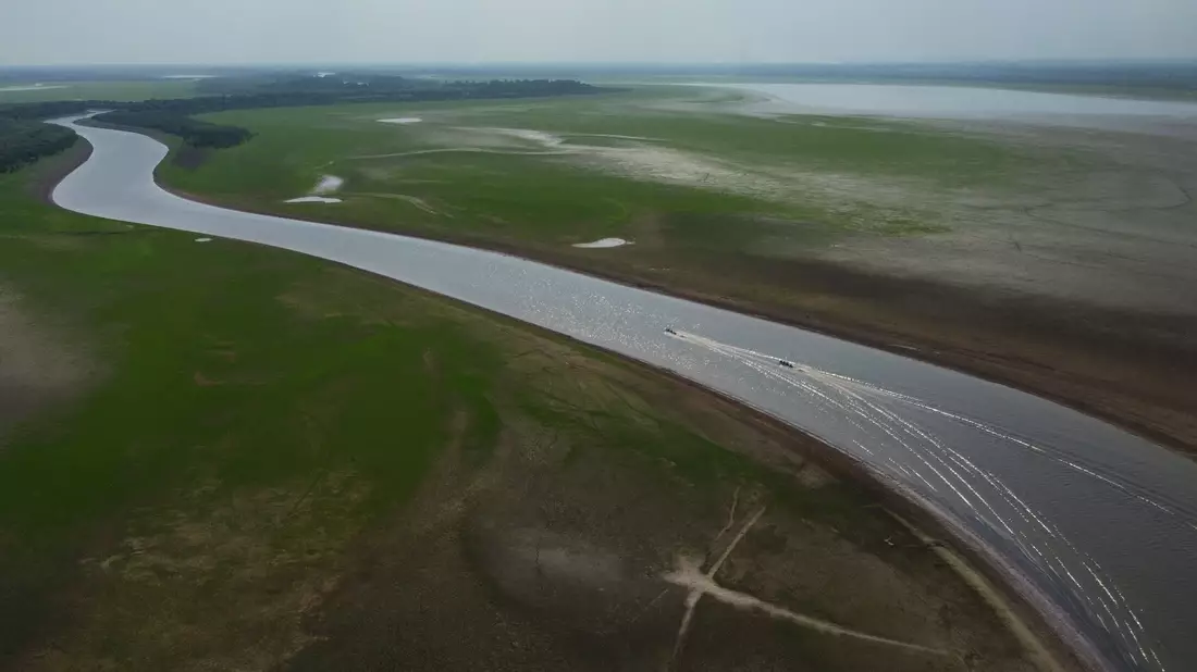 Boote fahren durch einen Abschnitt des Amazonas, der von einer schweren Dürre im Bundesstaat Amazonas betroffen ist. - Bild: Edmar Barros/AP