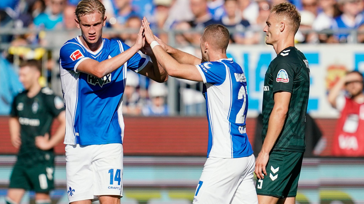 Tim Skarke (M) feiert mit Christoph Klarer (l) den ersten Darmstädter Saisonsieg. - Foto: Uwe Anspach/dpa