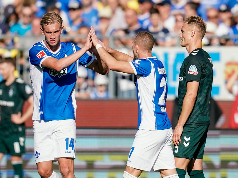 Tim Skarke (M) feiert mit Christoph Klarer (l) den ersten Darmstädter Saisonsieg. - Foto: Uwe Anspach/dpa