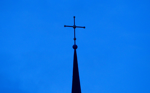 Kreuz einer evangelisch-lutherischen Kirche in der Abenddämmerung. - Foto: Friso Gentsch/dpa