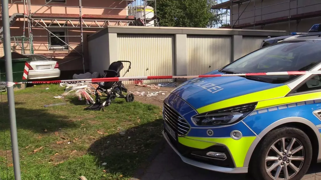 Ein Auto (links hinten) steht an einem Haus, nachdem der Fahrer zuvor eine Frau und ein Kind angefahren und lebensgefährlich verletzt hatte. - Bild: Justin Brosch/dpa