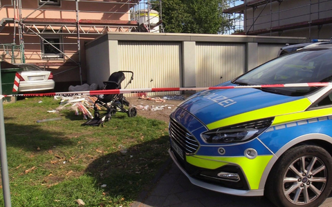 Ein Auto (links hinten) steht an einem Haus, nachdem der Fahrer zuvor eine Frau und ein Kind angefahren und lebensgefährlich verletzt hatte. - Foto: Justin Brosch/dpa