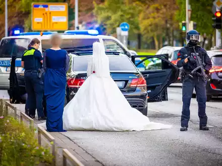 Polizisten kontrollieren Teilnehmer eines Hochzeitskorsos und ihre Fahrzeuge. - Foto: Moritz Frankenberg/dpa