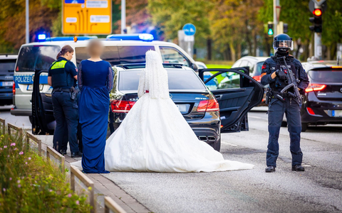 Polizisten kontrollieren Teilnehmer eines Hochzeitskorsos und ihre Fahrzeuge. - Foto: Moritz Frankenberg/dpa