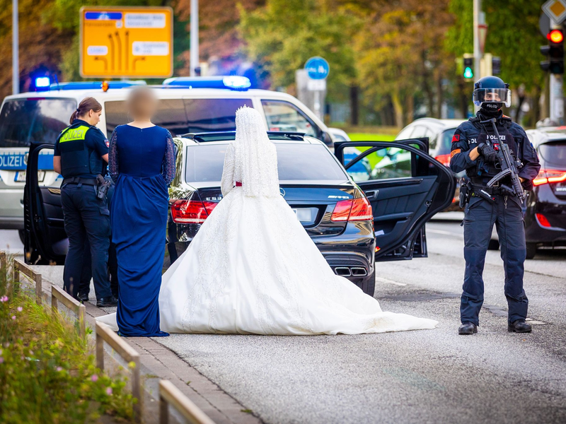 Polizisten kontrollieren Teilnehmer eines Hochzeitskorsos und ihre Fahrzeuge. - Foto: Moritz Frankenberg/dpa