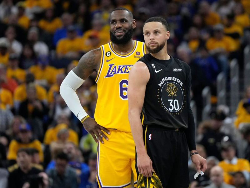 Stephen Curry (r) und LeBron James können sich vorstellen, bei den Olympischen Spielen in Paris dabei zu sein. - Foto: Jeff Chiu/AP/dpa
