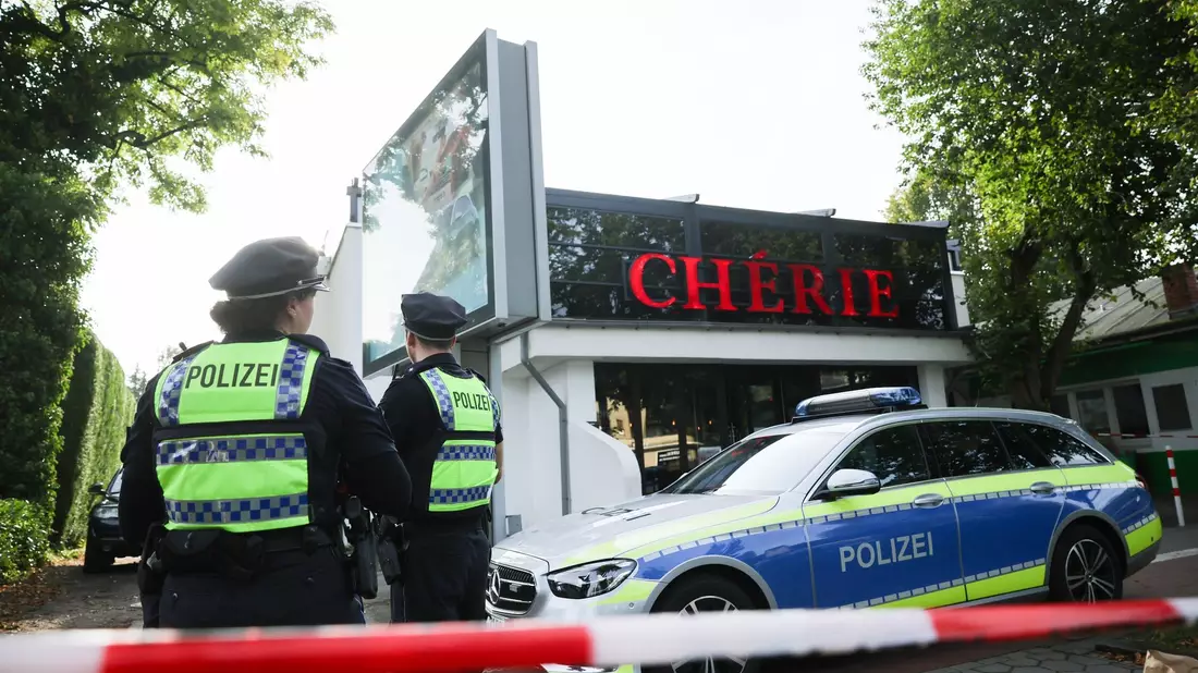 Polizeibeamte stehen vor der Shisha-Bar in Hamburg, wo ein 24-Jähriger erschossen worden war. - Bild: Christian Charisius/dpa