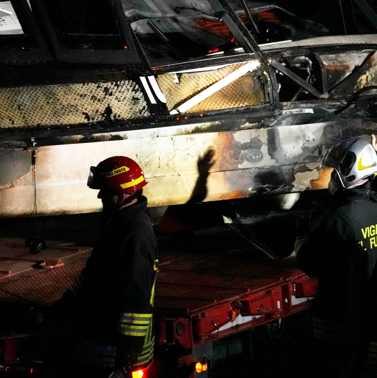 Feuerwehrleute arbeiten nach dem Busunglück an der Unfallstelle. - Foto: Antonio Calanni/AP