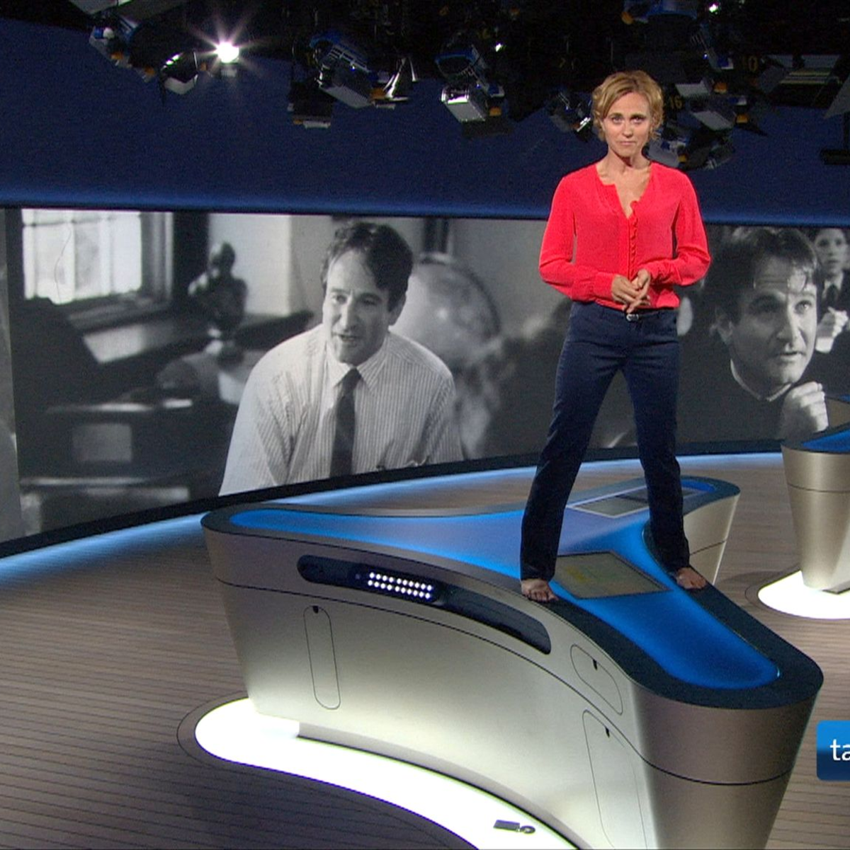 Caren Miosga 2014 auf dem Moderatorentisch in Erinnerung an den verstorbenen Schauspieler Robin Williams. - Foto: NDR/dpa