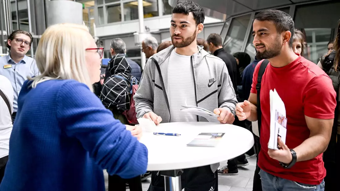 Gulan und Achmad aus Afghanistan informieren sich auf der Jobmesse «FuTog Berlin» (FutureTogether Berlin) für Geflüchtete. - Bild: Britta Pedersen/dpa