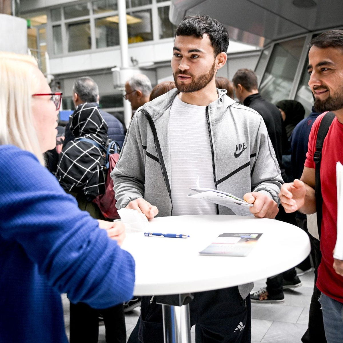 Gulan und Achmad aus Afghanistan informieren sich auf der Jobmesse «FuTog Berlin» (FutureTogether Berlin) für Geflüchtete. - Foto: Britta Pedersen/dpa