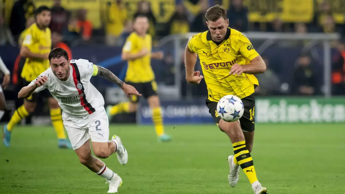 BVB-Torjäger Niclas Füllkrug (r) im Laufduell mit Milans Davide Calabria. - Bild: Bernd Thissen/dpa