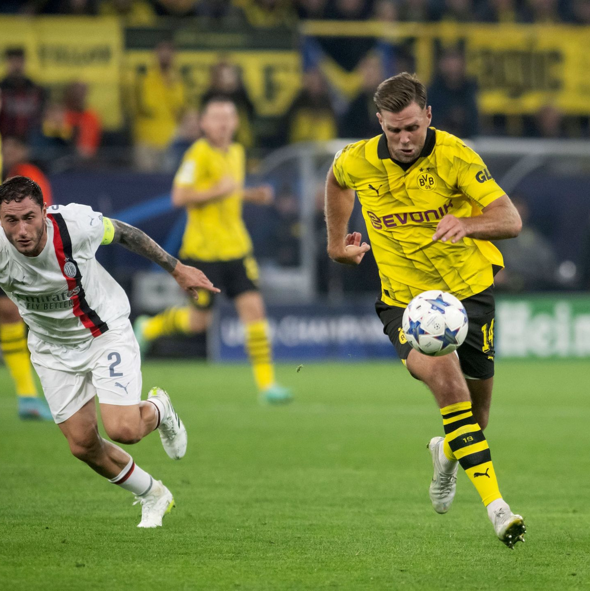 BVB-Torjäger Niclas Füllkrug (r) im Laufduell mit Milans Davide Calabria. - Foto: Bernd Thissen/dpa