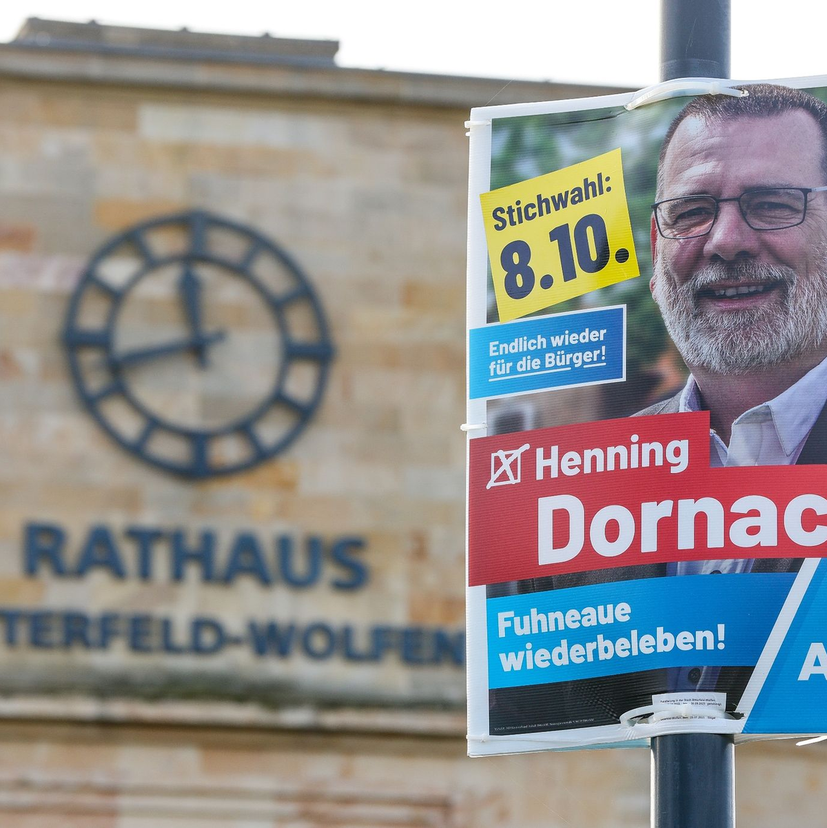 Ein Wahlplakat des AfD-Kandidaten Henning Dornack hängt vor dem Rathaus von Bitterfeld-Wolfen. - Foto: Jan Woitas/dpa