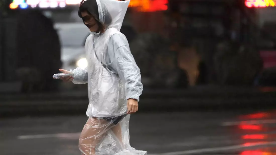 Eine Frau läuft bei Regen und Wind durch Taipeh. - Bild: ChiangYing-ying/AP/dpa