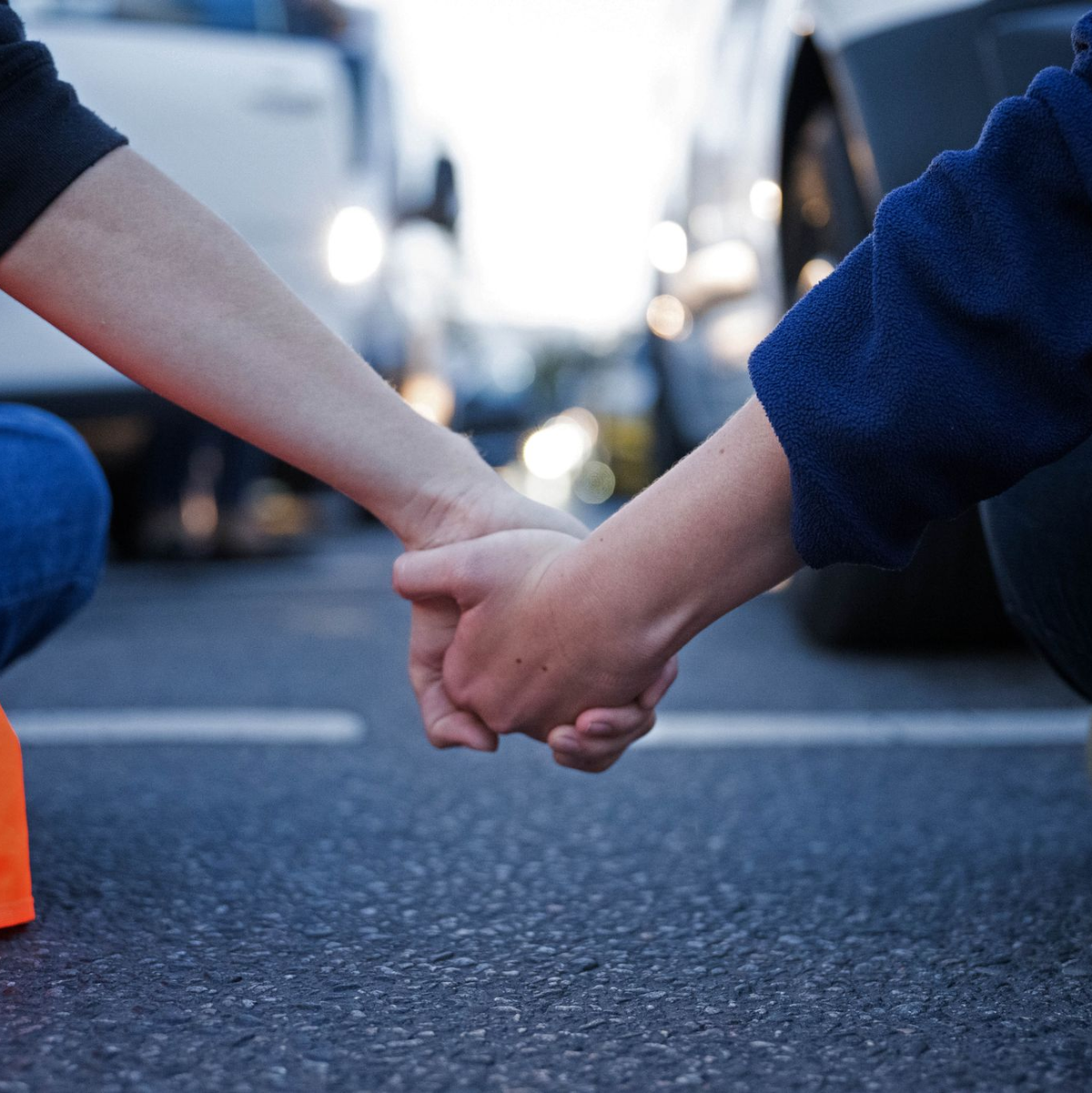 Aktivisten der Klimaschutzgruppe Letzte Generation halten sich während einer Straßenblockade an den Händen (Symbolbild). - Foto: Sebastian Christoph Gollnow/dpa