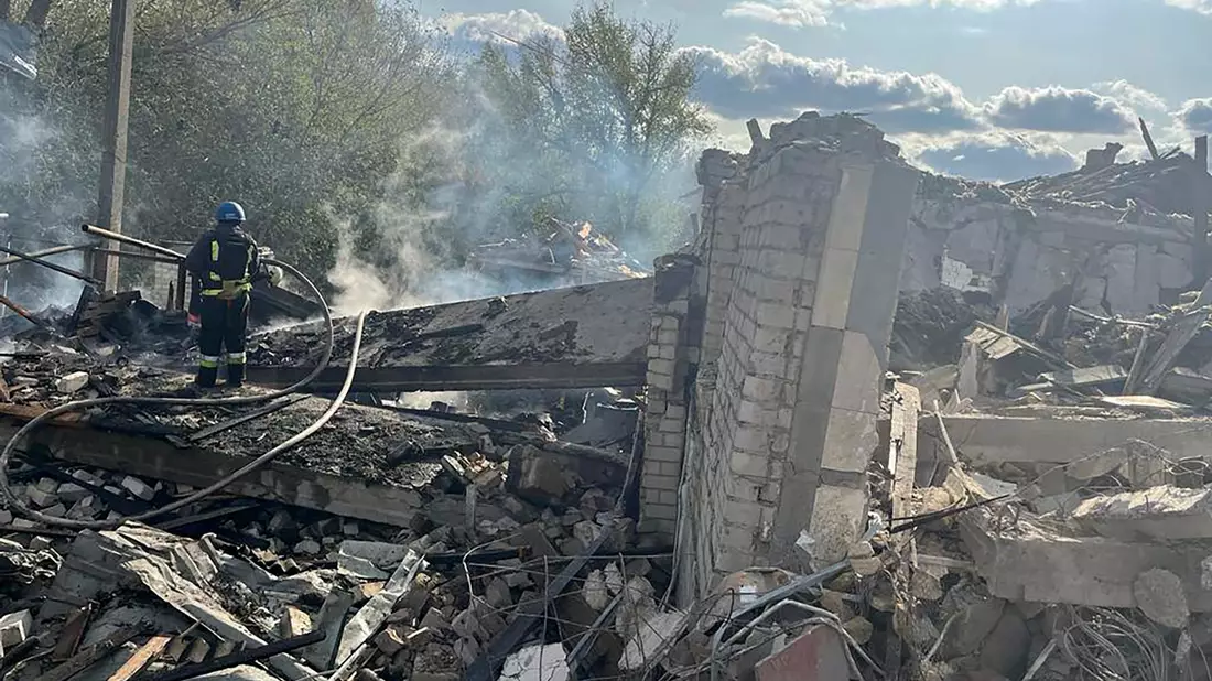 Feuerwehrleute umgeben von Trümmern im ukrainischen Dorf Hrosa. Ein russischer Raketenangriff hat hier Dutzende Menschen getötet. - Bild: Uncredited/Ukrainian Presidential Press Office/AP