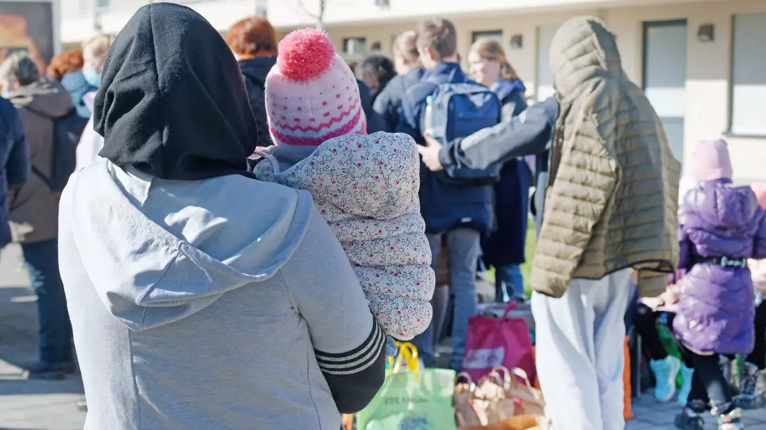 Geflüchtete aus der Ukraine stehen vor den Gebäuden einer Flüchtlingsunterkunft in Köln. - Bild: Henning Kaiser/dpa