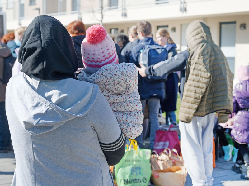 Geflüchtete aus der Ukraine stehen vor den Gebäuden einer Flüchtlingsunterkunft in Köln. - Foto: Henning Kaiser/dpa