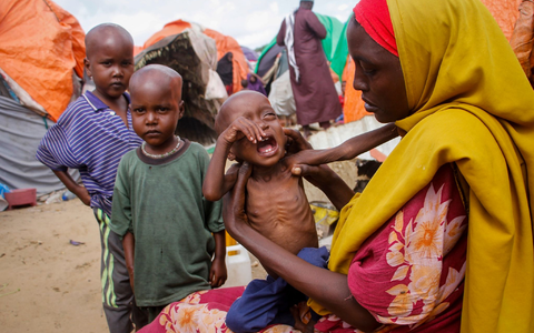 Eine Mutter, die aus der von Dürre heimgesuchten Region Lower Shabelle geflohen ist, hält ihre unterernährte Tochter in einem Lager für Vertriebene. - Foto: Farah Abdi Warsameh/AP/dpa