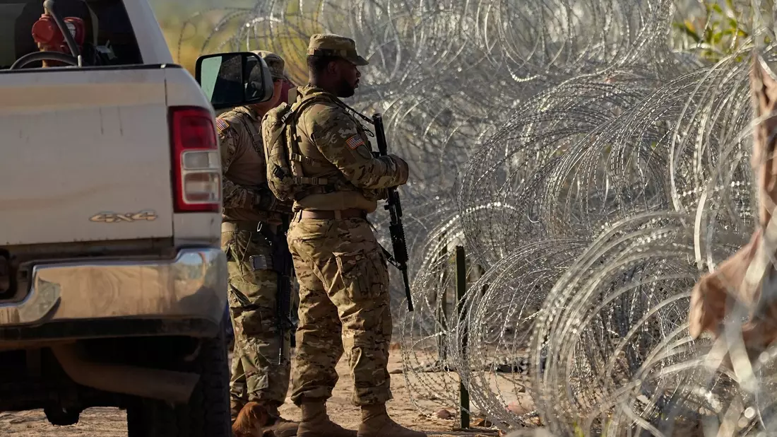 Soldaten stehen neben einem Stacheldrahtzaun am Ufer des Rio Grande Wache. - Bild: Eric Gay/AP/dpa