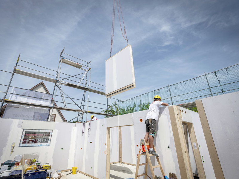 Ein Bauarbeiter arbeitet im Rohbau eines Fertighauses. - Foto: Daniel Maurer/dpa