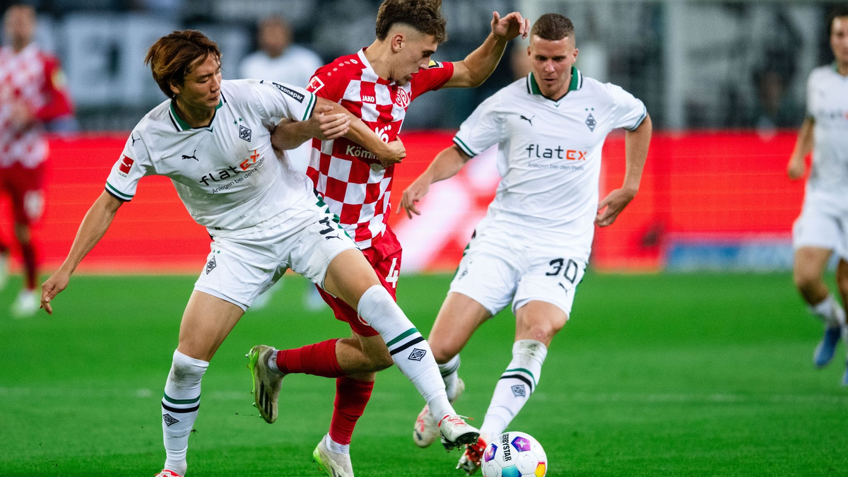 Nach einem harten Kampf trennen sich Gladbachs Ko Itakura (l) und der Mainzer Brajan Gruda (M)und ihre Teams 1:1. - Foto: Marius Becker/dpa