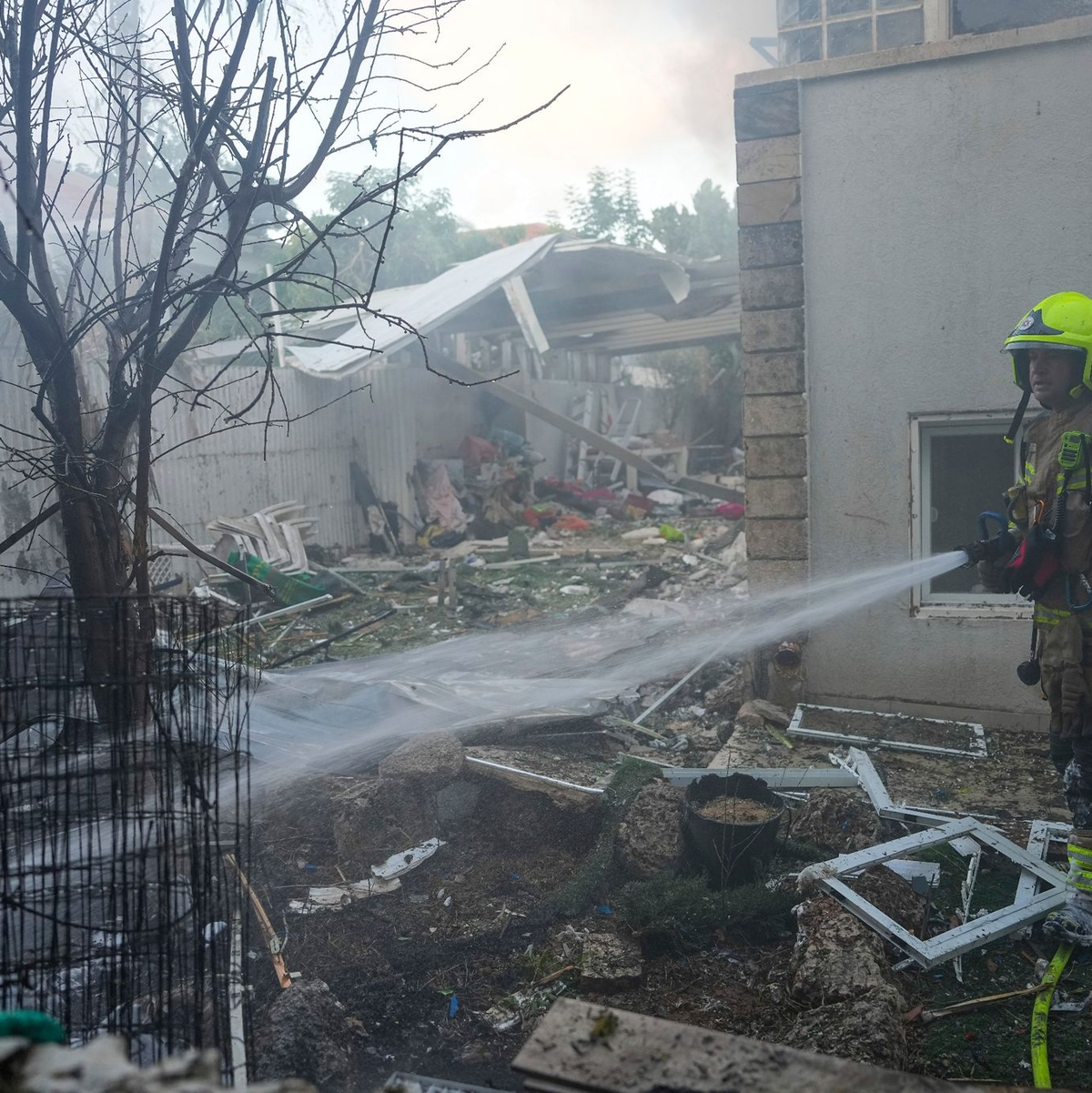 Israelische Feuerwehrleute löschen ein Feuer, nachdem eine aus dem Gazastreifen abgefeuerte Rakete ein Haus im Süden Israels getroffen hat. - Foto: Tsafrir Abayov/AP