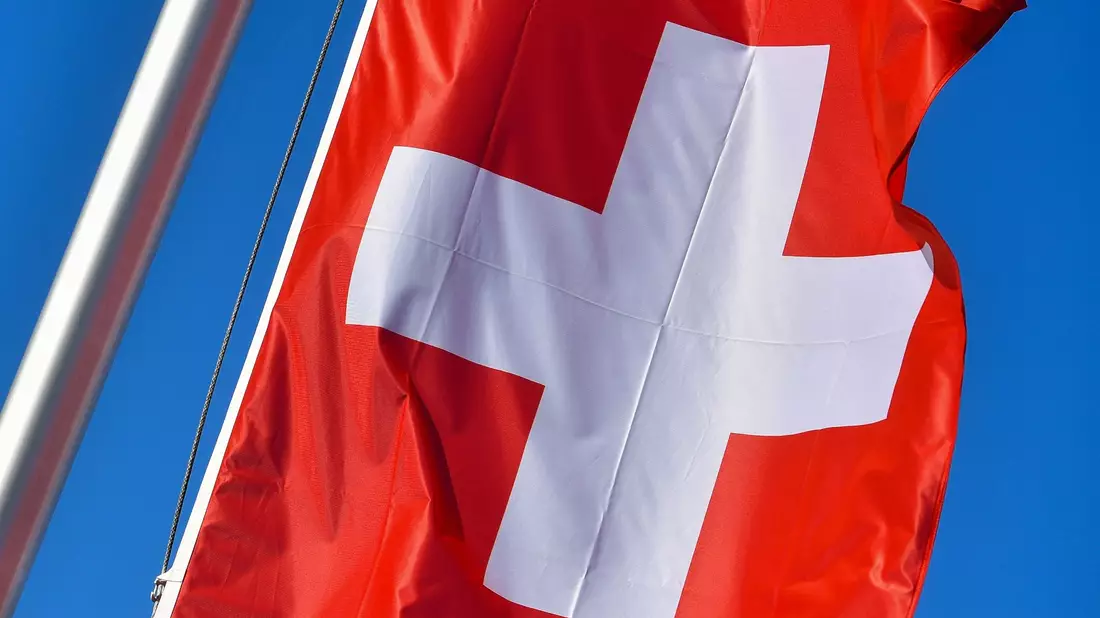 Die Nationalflagge der Schweiz weht vor blauem Himmel. In Zürich kam es zu einem gefährlichen Zwischenfall. - Bild: Patrick Pleul/dpa-Zentralbild/dpa