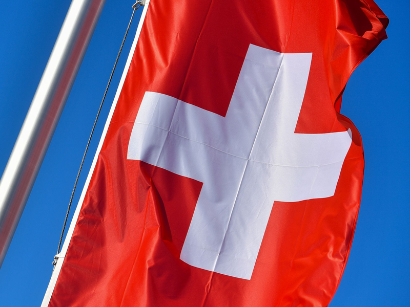 Die Nationalflagge der Schweiz weht vor blauem Himmel. In Zürich kam es zu einem gefährlichen Zwischenfall. - Foto: Patrick Pleul/dpa-Zentralbild/dpa