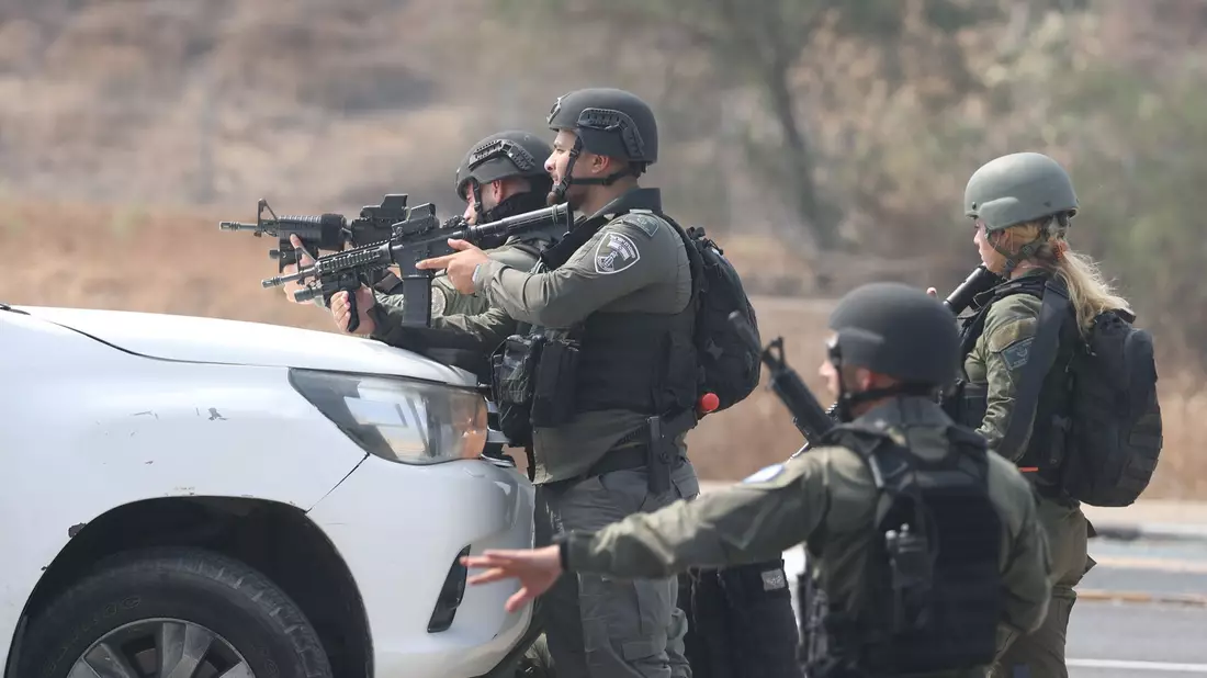 Israelische Streitkräfte gehen hinter einem Fahrzeug in Sderot in Stellung. - Bild: Ilia Yefimovich/dpa