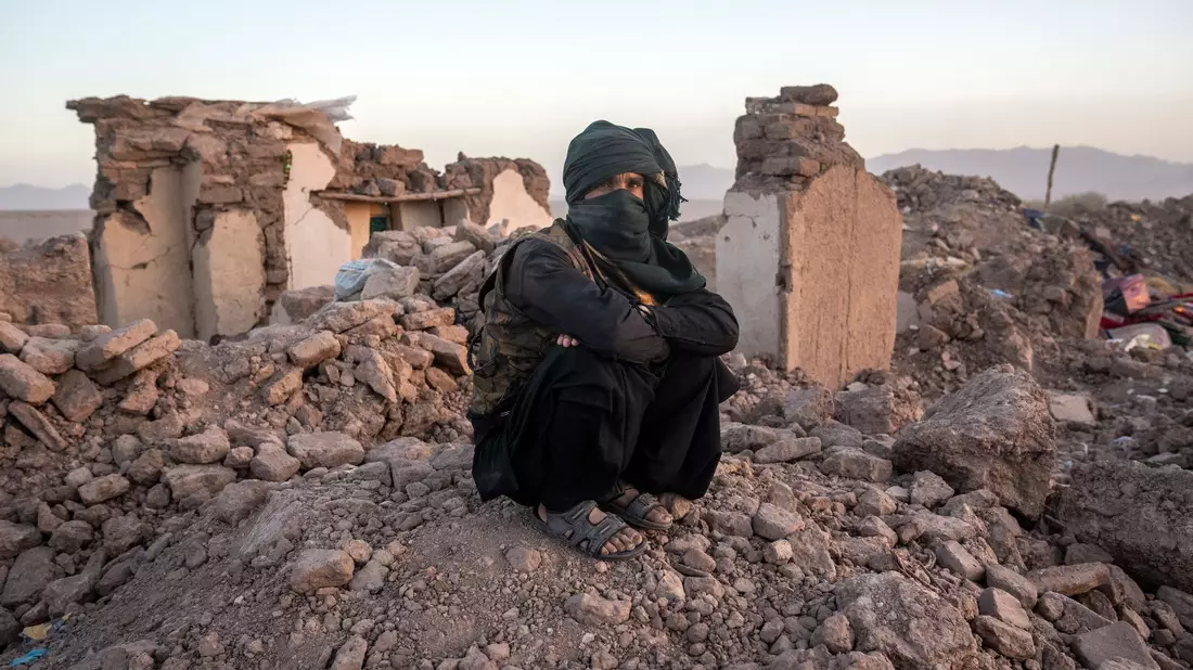 Ein Afghane sitzt in den Trümmern seines Hauses im Bezirk Zenda Jan in der Provinz Herat. - Bild: Ebrahim Noroozi/AP/dpa