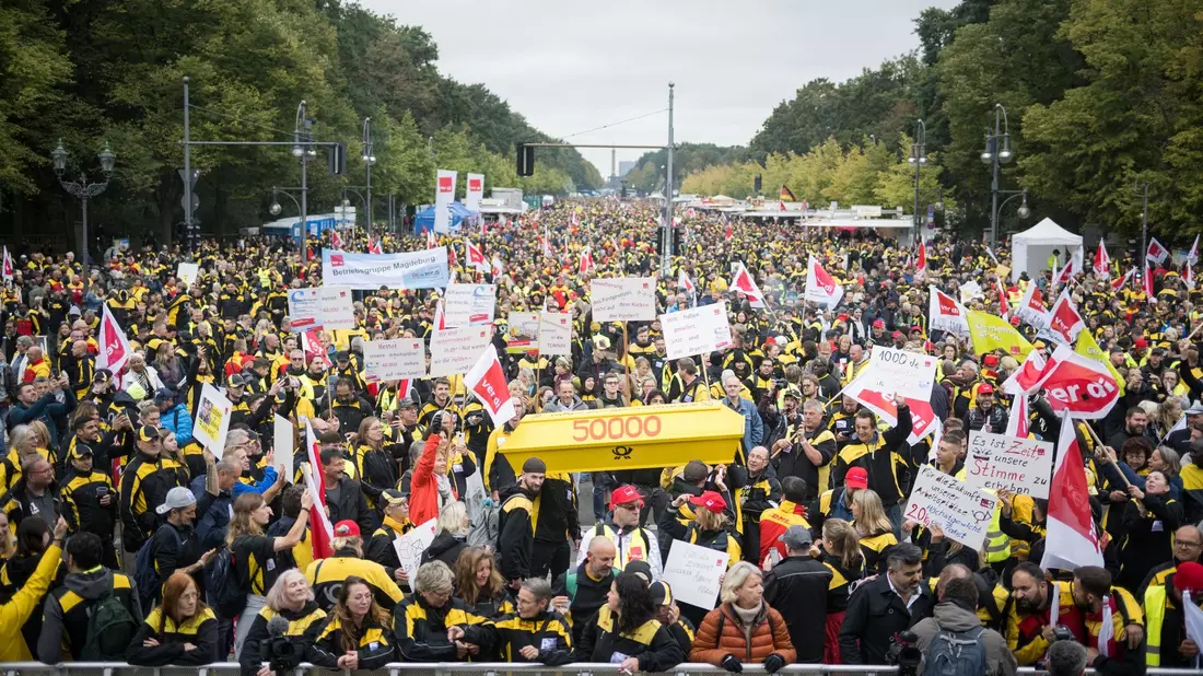 Postmitarbeiter stehen während einer Verdi-Großkundgebung zur Novelle des Postgesetzes auf der Straße des 17. Juni. - Bild: Sebastian Christoph Gollnow/dpa