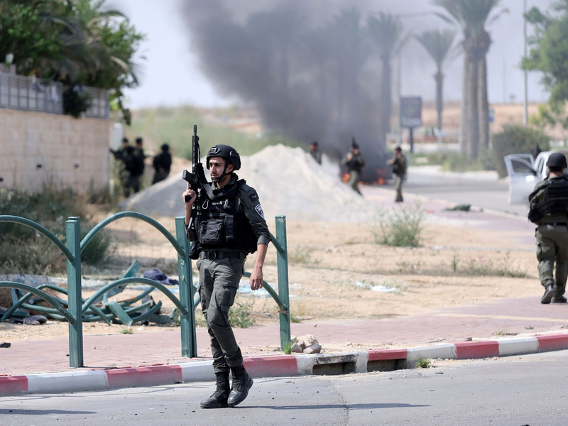 Israelische Soldaten gehen nach dem Hamas-Terrorangriff durch einen Grenzort. - Foto: Ilan Assayag/AP/dpa