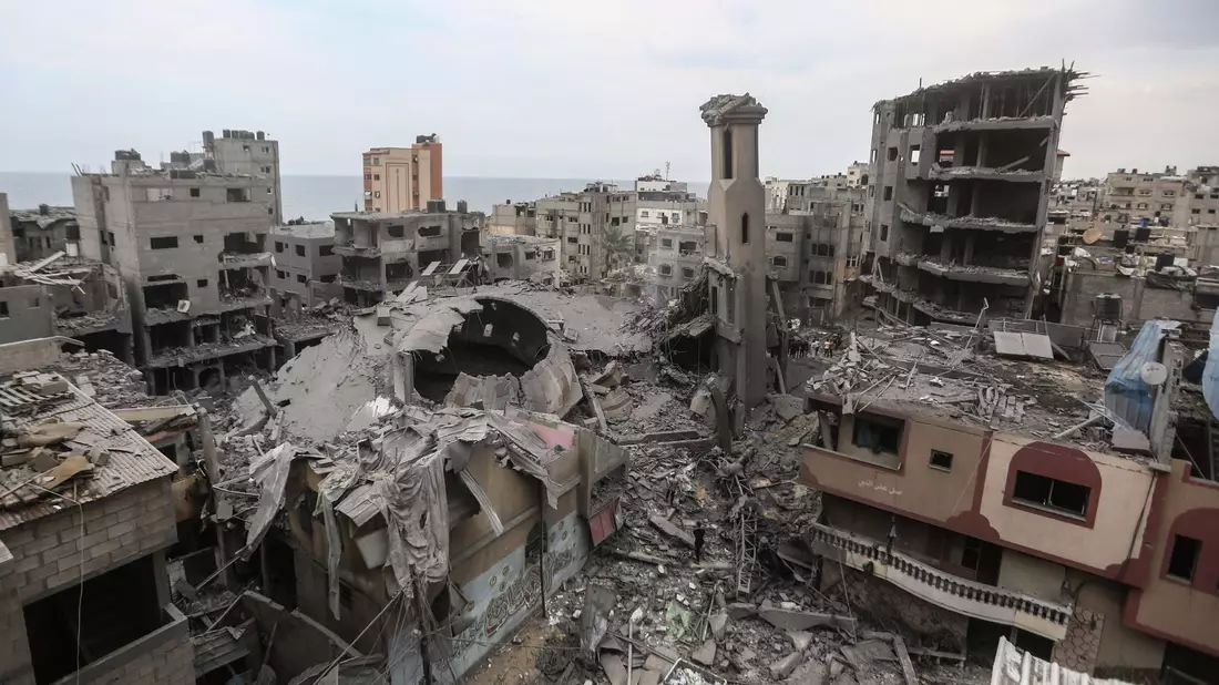 Eine Frau geht durch das Karama-Viertel in Gaza-Stadt nach einem israelischen Luftangriff. - Bild: Mohammed Talatene/dpa