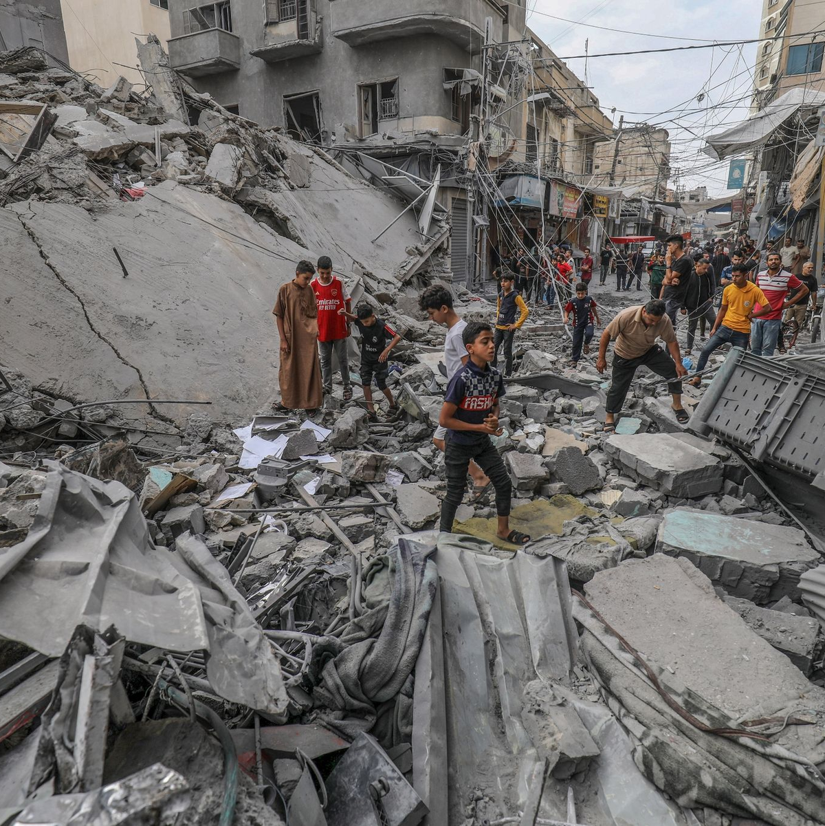 Palästinenser laufen nach einem israelischen Luftangriff im Gazastreifen zwischen den Trümmern eines zerstörten Gebäudes umher. - Foto: Abed Rahim Khatib/dpa