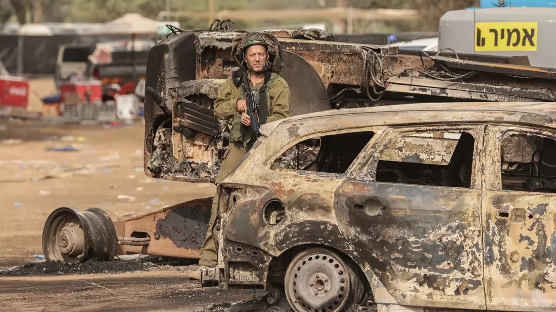 Ein israelischer Soldat steht auf dem Gelände des elektronischen Musikfestivals Supernova nach dem tödlichen Angriff islamistischer Hamas-Kämpfer vom 07.10.2023, bei dem 260 Menschen starben und mehr als 100 Menschen als Geiseln genommen wurden. - Bild: Ilia Yefimovich/dpa