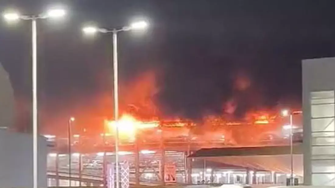 Flammen schlagen aus der obersten Etage eines mit vielen Autos besetzten Parkhauses am Londoner Flughafen Luton (Screenshot aus einem bei X geposteten Video). - Bild: @Soriyn23/PA Media/dpa